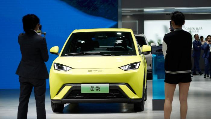 People use their phones in front of the BYD Seagull that is displayed at the Auto Shanghai show, in Shanghai, China April 19, 2023. REUTERS/Aly Song