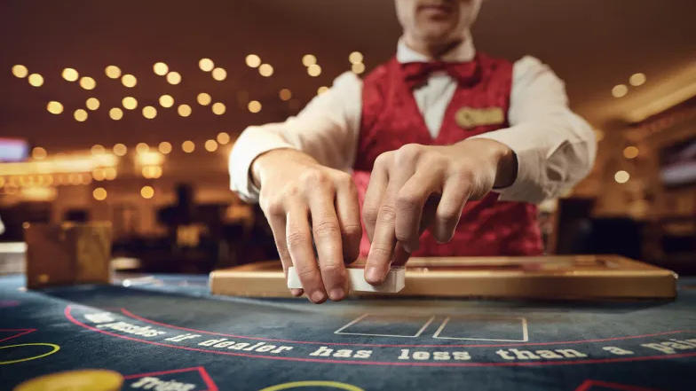 Photo of a casino dealer handing out chips.